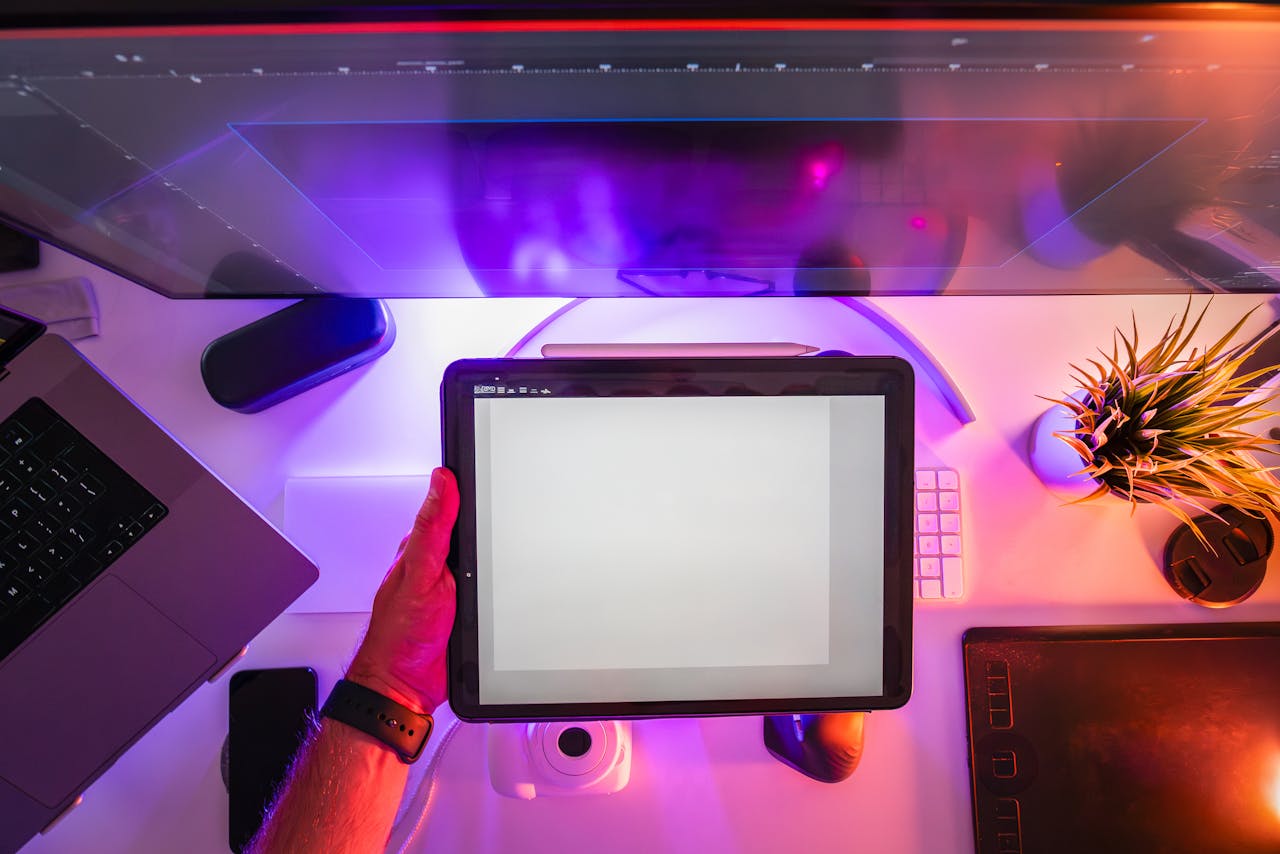 A vibrant workspace featuring a digital tablet and neon lighting, ideal for designers or photographers.